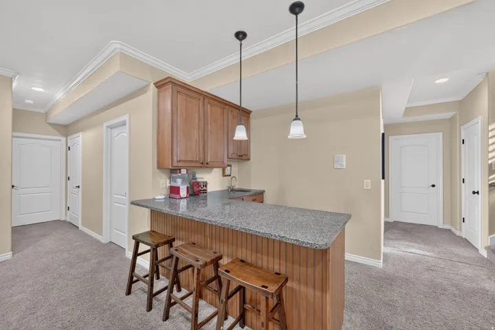 Downstairs kitchenette with barstools, cabinets, and countertops
