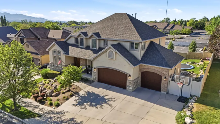Front house exterior showcasing 3 car garage, mature trees, basketball hoop, and RV parking, and extra street/ side parking