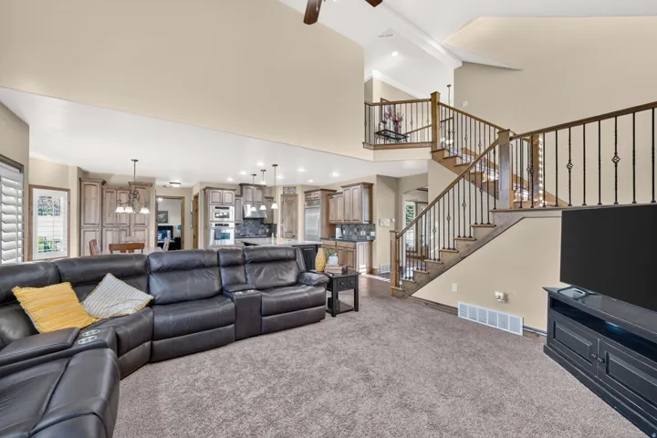 Large living room with ample seating, and views of the large staircase going upstairs
