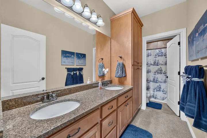 Downstairs bathroom with double vanity sink, walk in shower, and lots of storage space