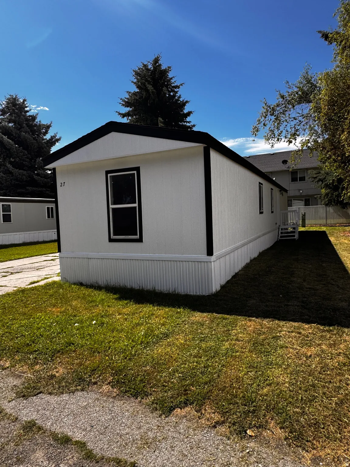 White exterior with black trim and a dark-pitched roof