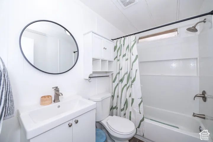 Bathroom featuring a white vanity with integrated sink, brushed nickel faucet, and circular black-framed mirror