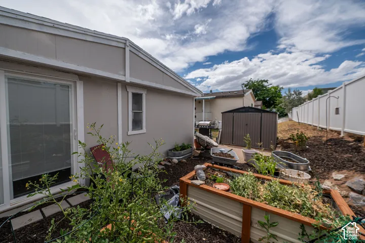 Expansive backyard featuring a privacy fence, built-in planters, and an outdoor storage shed