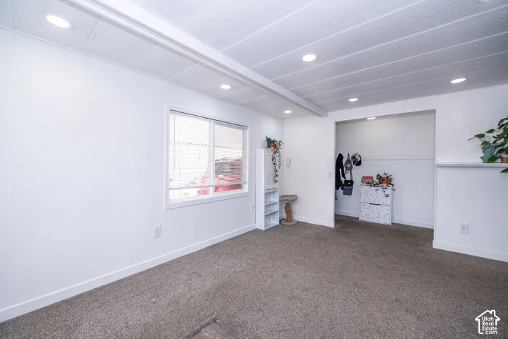 Bright interior space featuring recessed lighting, a window with white trim, and neutral carpeting