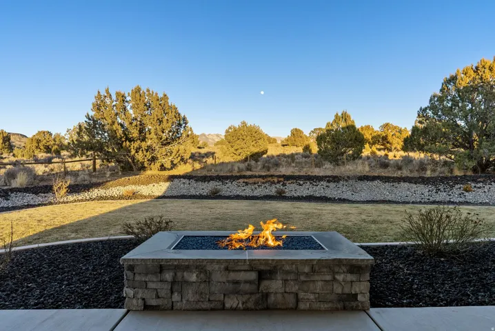 Stone-clad fire pit with a concrete cap and blue fire glass