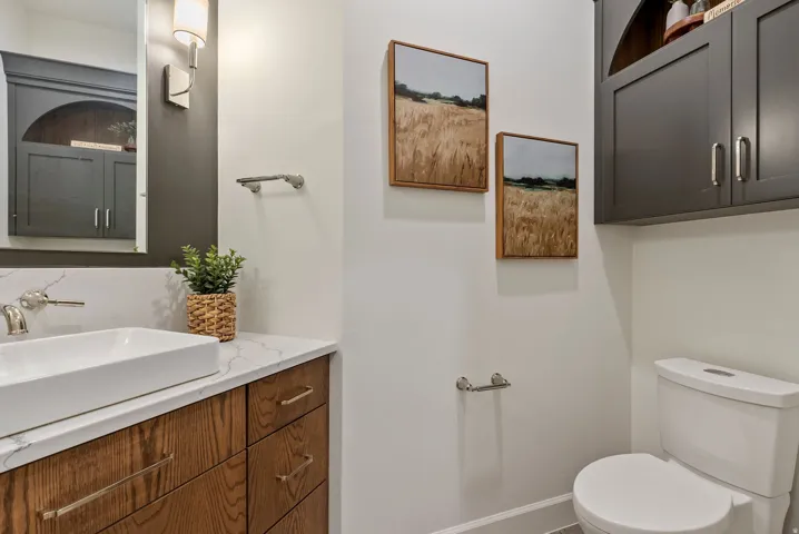 Modern vanity featuring a rectangular vessel sink, wall-mounted faucet, and wood-finish cabinetry