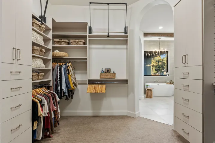 Custom closet system featuring built-in cabinetry, shelving, and hanging rods