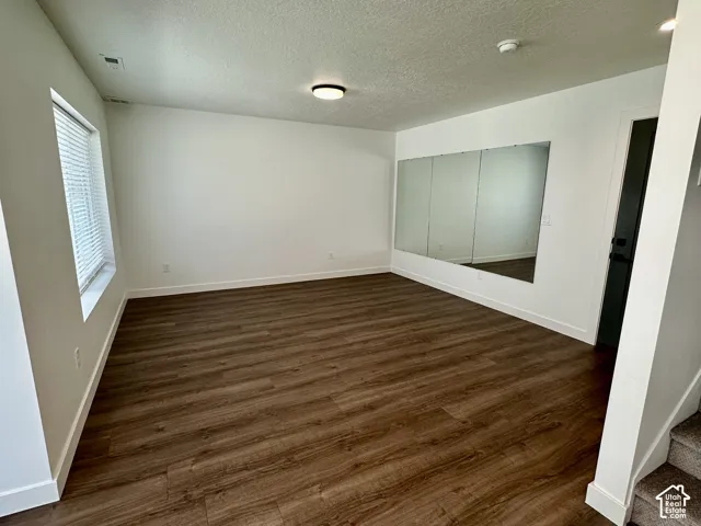 Flex room can be used as office, exercise room or anything you want. Wood-finish flooring, white walls, large framed mirror, window with blinds.