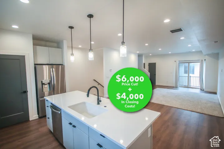 Kitchen island with solid-surface countertop, undermount sink, matte black faucet, and recessed lighting