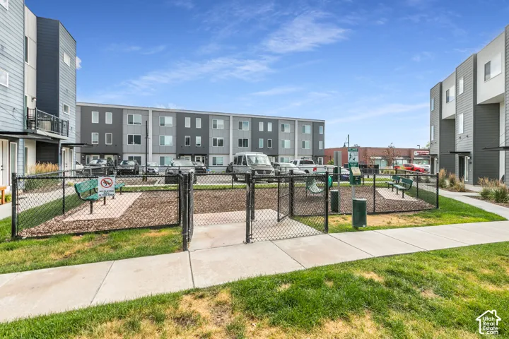 Fenced pet recreation area featuring integrated seating, wood mulch ground cover, and waste disposal station