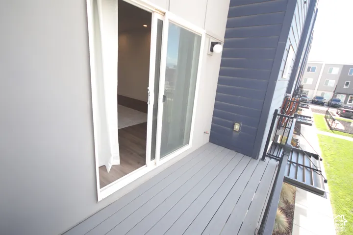 Exterior deck featuring composite gray decking, black metal railing, sliding glass door