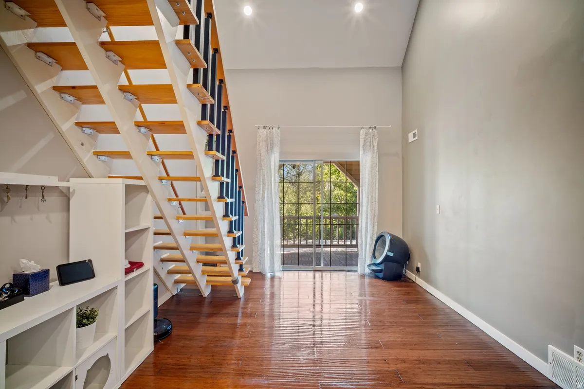 Open riser staircase with wood treads and black metal balusters