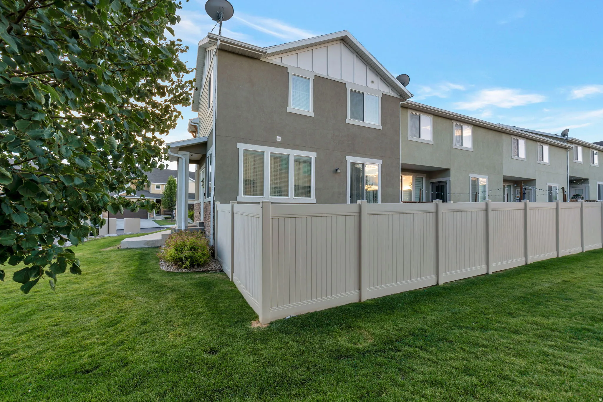 Fenced backyard featuring a manicured lawn, an extended patio, and stucco exterior