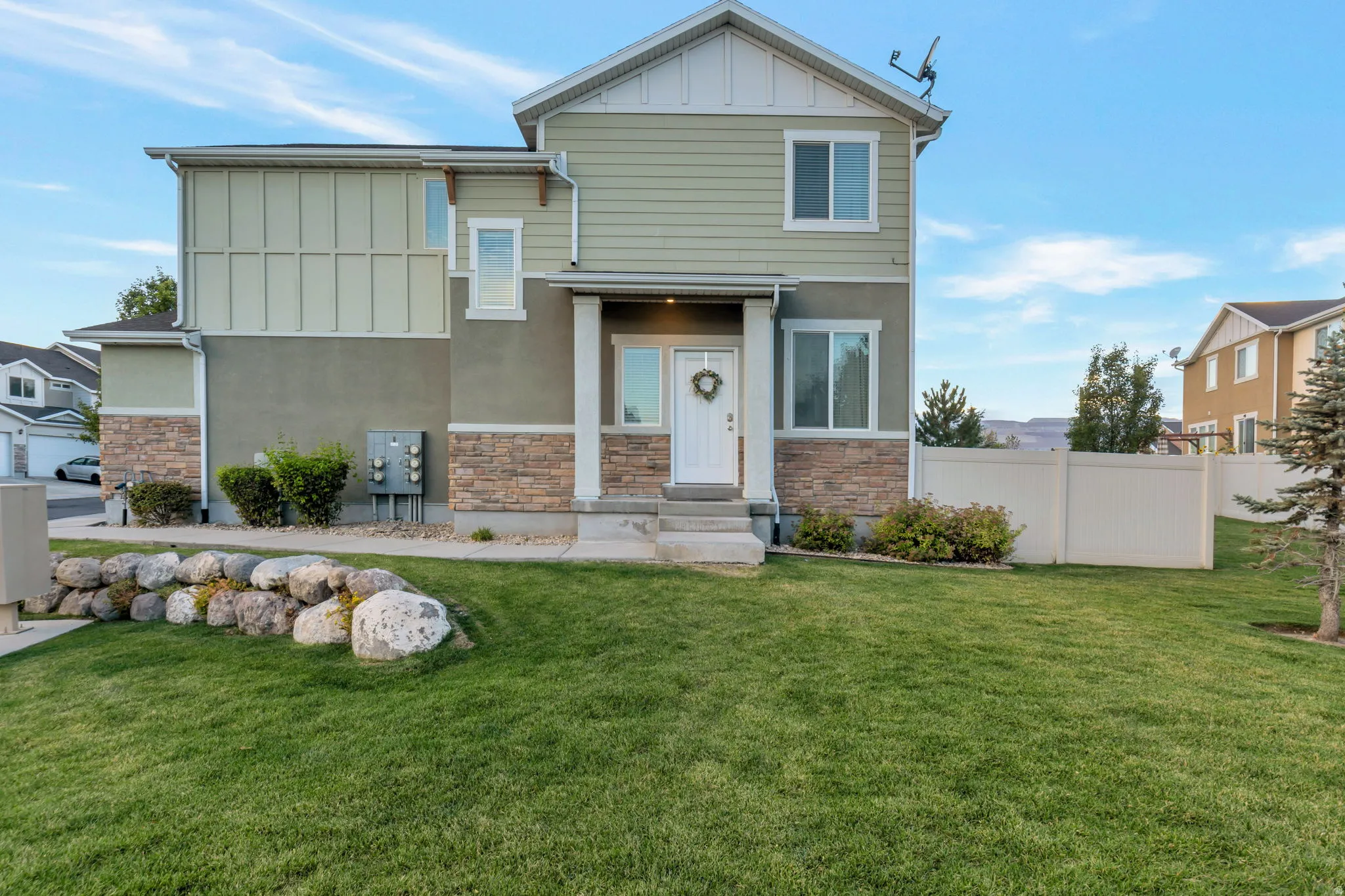 Two-story residence featuring a combination of stucco, horizontal siding, and stone veneer accents