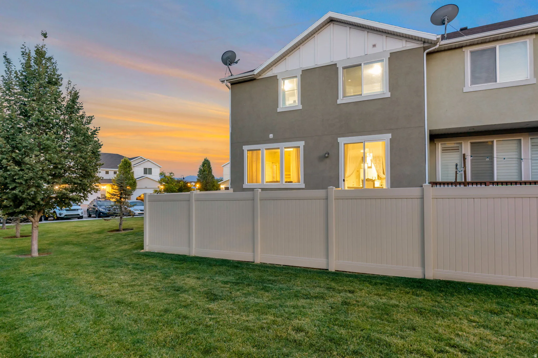 Expansive grassy area featuring a vinyl privacy fence