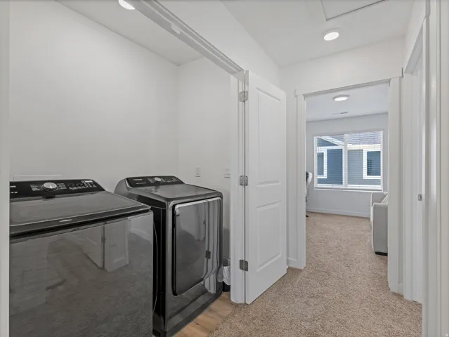 Dedicated laundry area featuring wood-finish flooring
