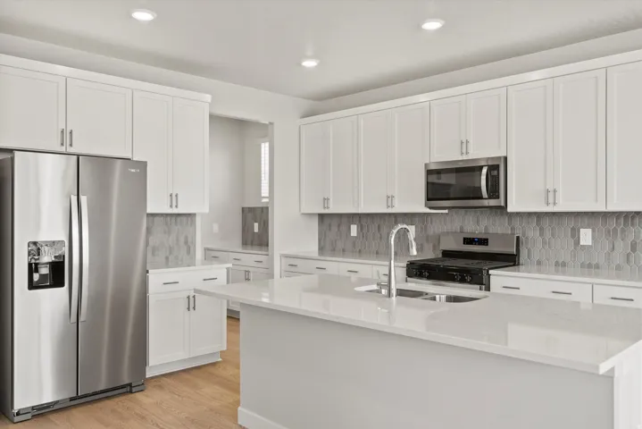 Kitchen featuring white shaker cabinetry and a large center island