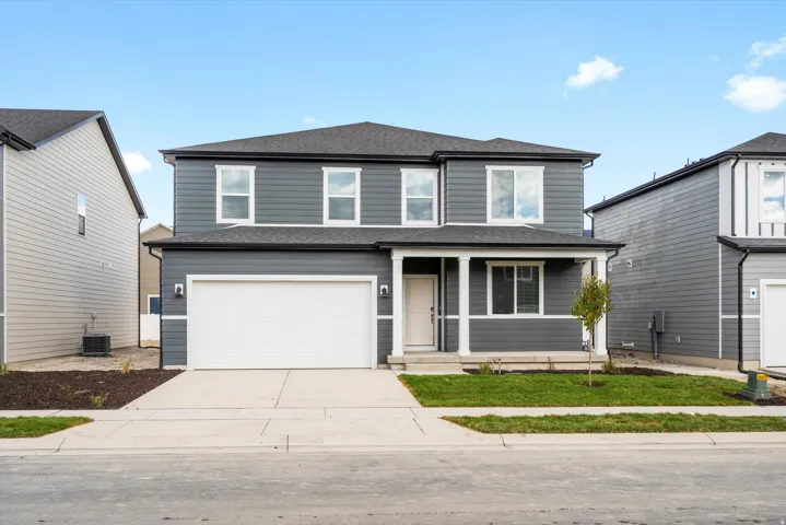 Two-story residence featuring a dark gray siding exterior with white trim accents and a two-car garage