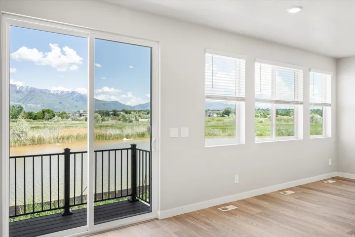Interior space featuring a sliding glass door opening to a balcony with black railings