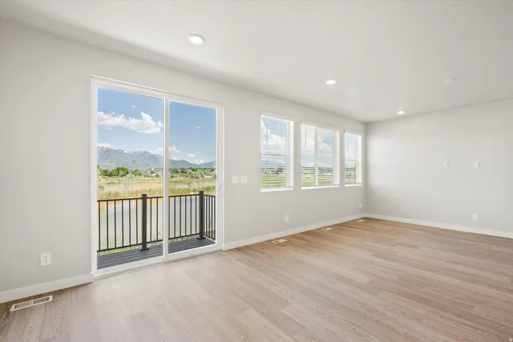 Spacious interior featuring light wood-finish flooring, recessed lighting, and white walls