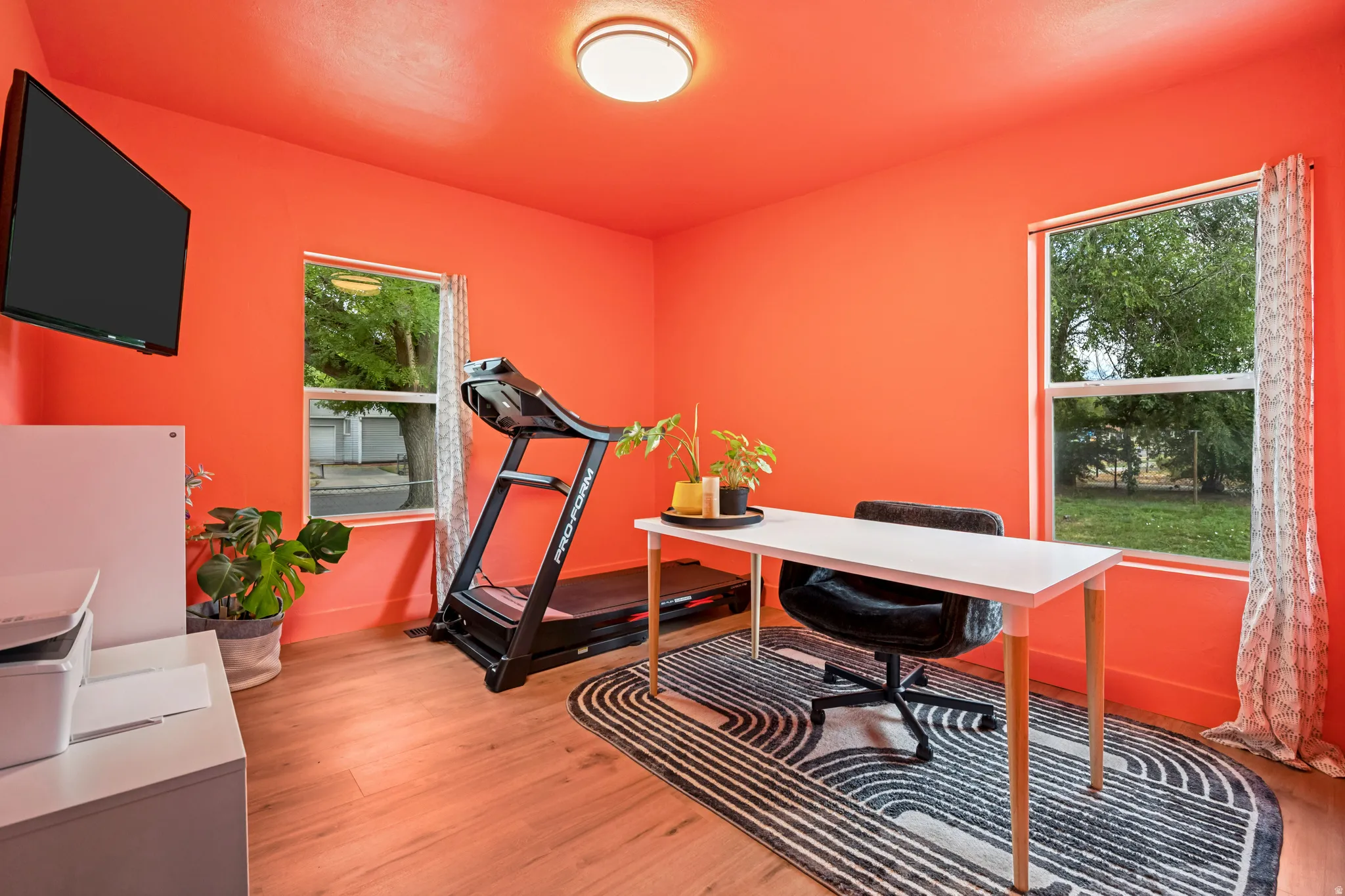 Room featuring wood-finish flooring, two windows, and a flush-mount ceiling light