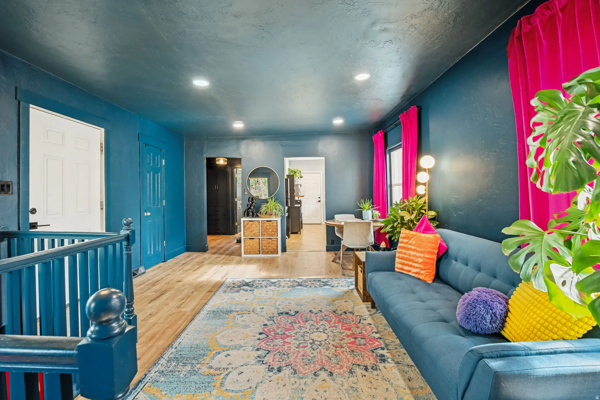 Open concept living area featuring recessed lighting, light wood-finish flooring, and a stairway with a coordinating baluster
