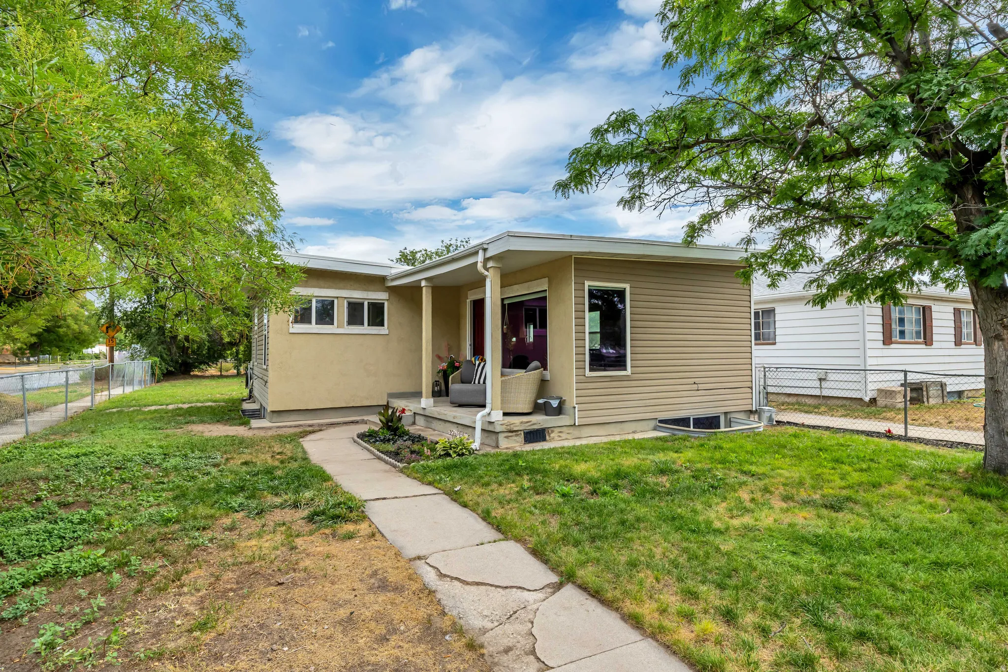 Exterior featuring a covered front porch, stucco finish, horizontal siding, and multiple windows