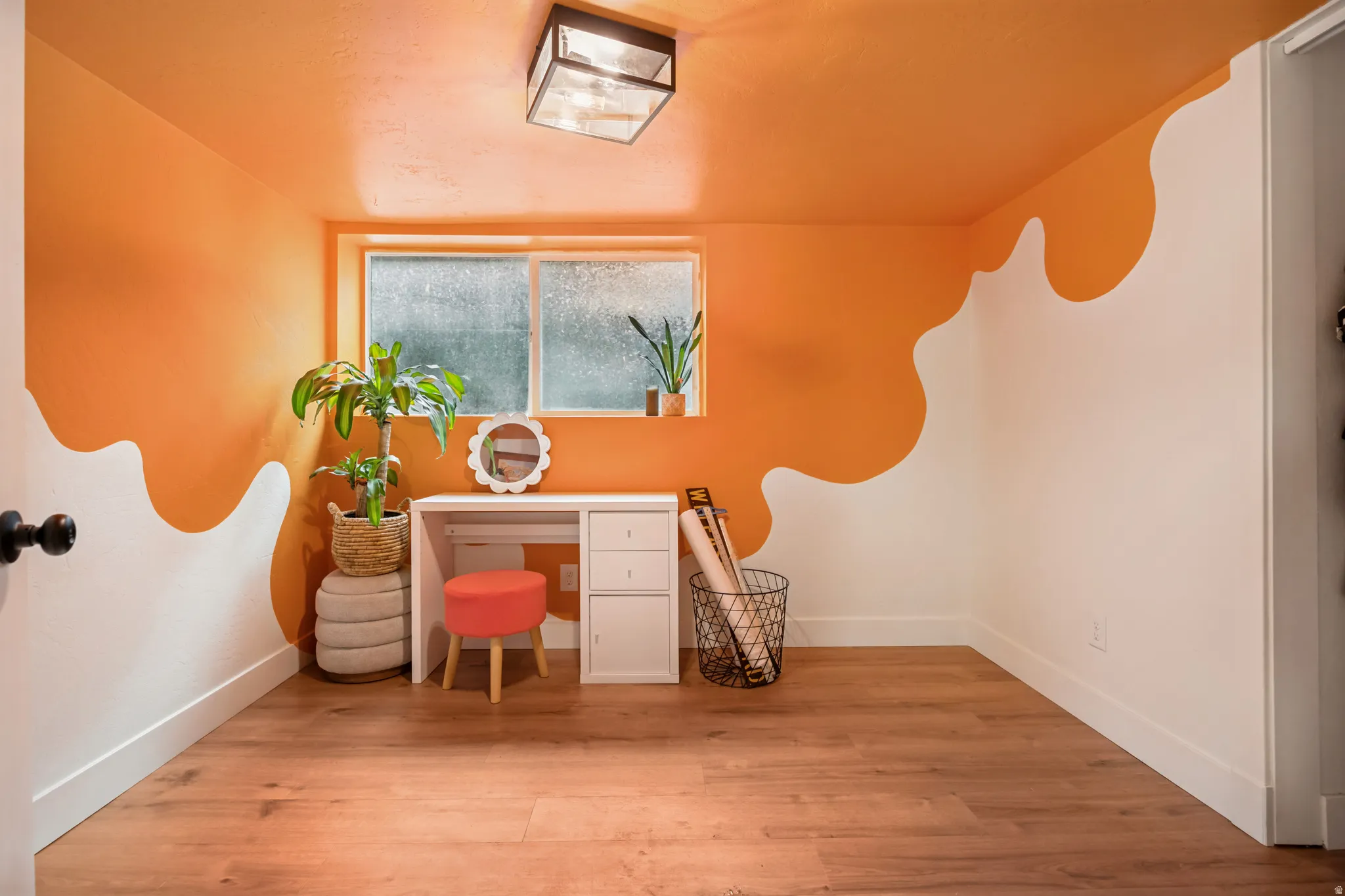Room featuring wood-finish flooring, a contemporary flush mount ceiling light, and a window with privacy glass