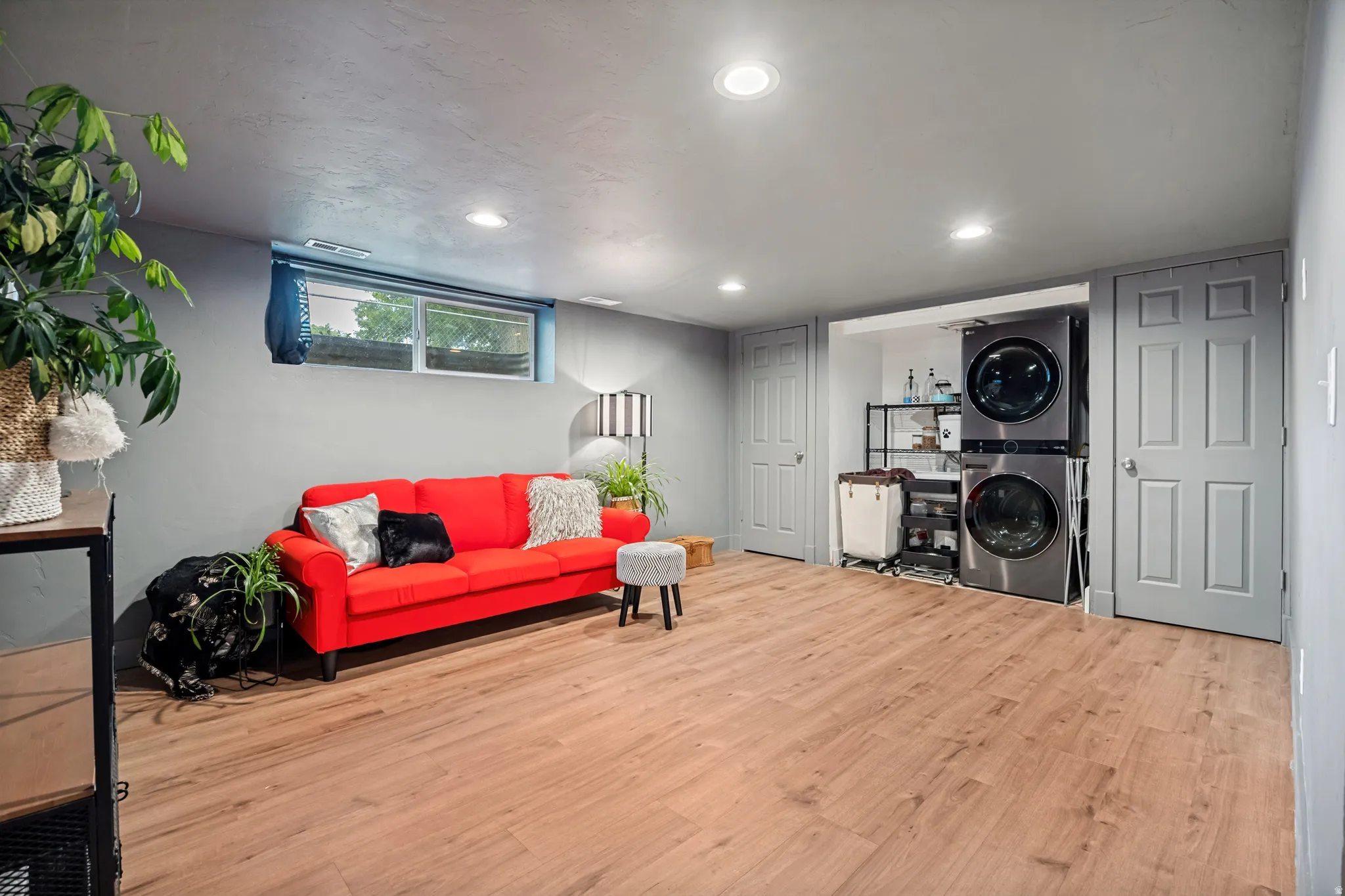 Spacious room featuring wood-finish flooring, recessed lighting, and a window