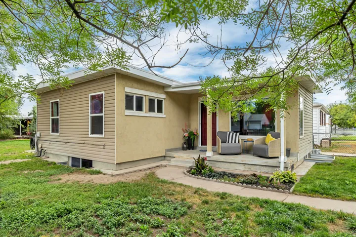 Exterior featuring a combination of stucco and horizontal siding, a covered front porch, a large picture window, and a red entry door