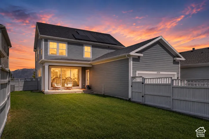 Rear exterior with gray siding, a covered patio, sliding glass doors, and a detached two-car garage