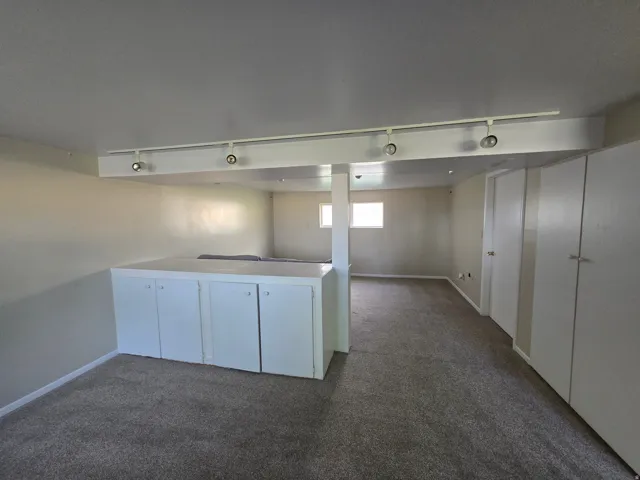 Basement famiy room with built in cabinets.