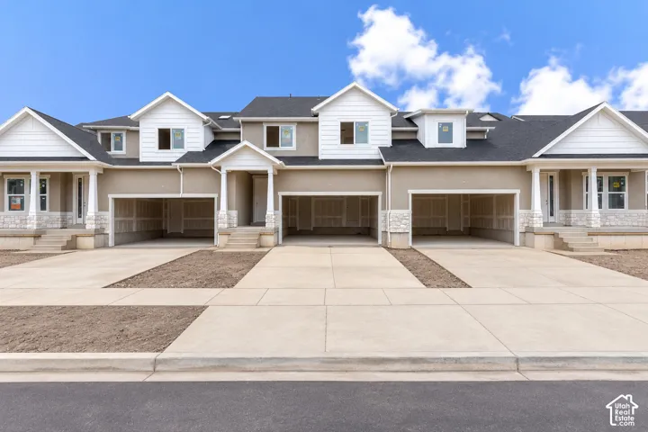 Exterior featuring a multi-unit design with gable rooflines, neutral stucco siding, stone masonry accents, and private multi-car garage bays