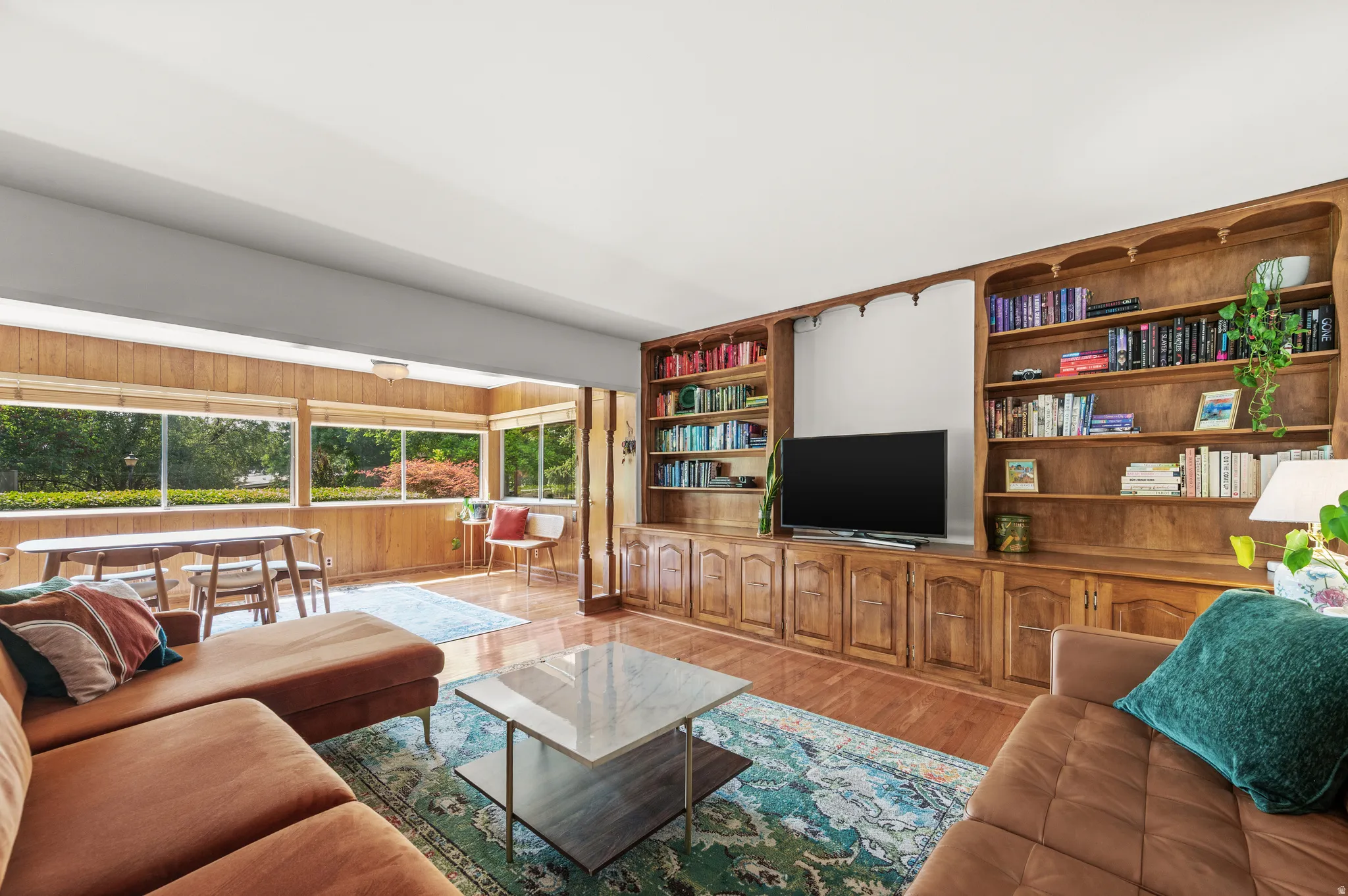 Living area featuring a floor-to-ceiling built-in entertainment center with extensive shelving and cabinetry