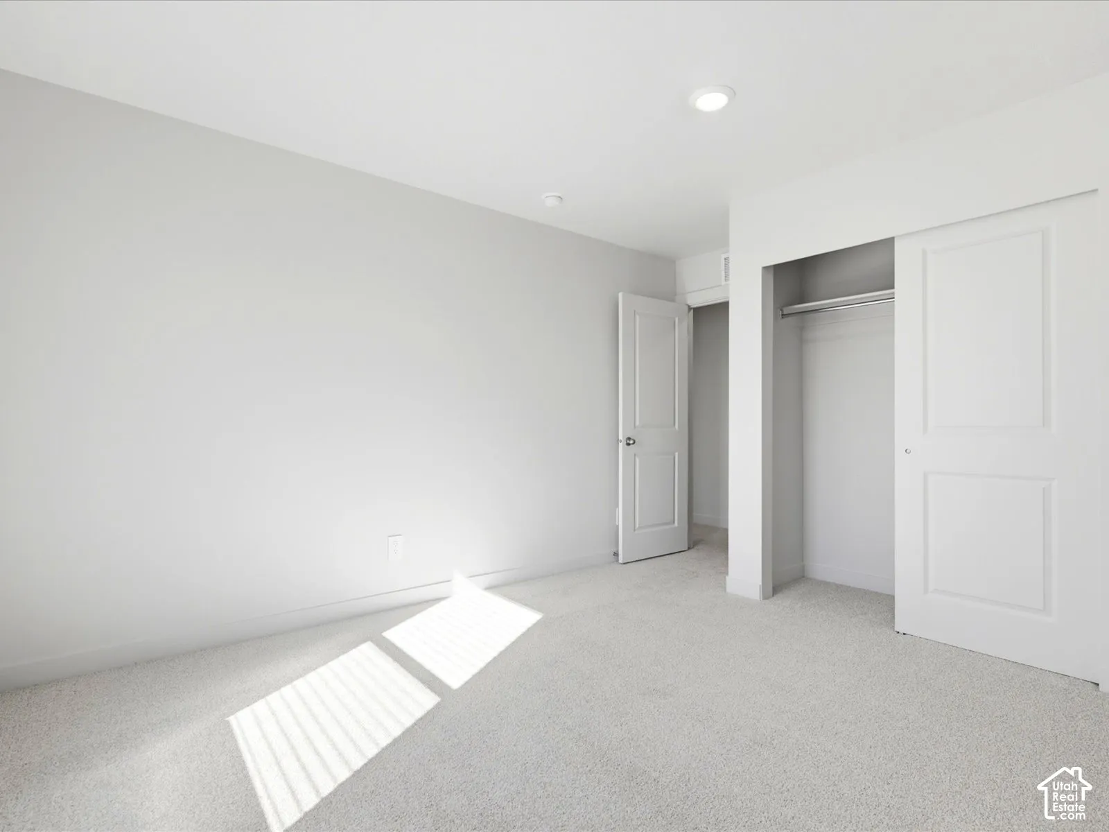 Neutral interior featuring wall-to-wall carpeting, recessed lighting, and a closet with sliding paneled doors
