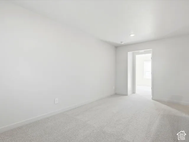 Interior space featuring neutral wall tones, plush wall-to-wall carpeting, and recessed ceiling lighting