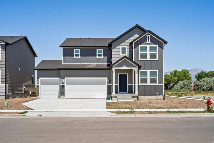 Two-story exterior with a covered entry, board and batten siding, and a two-car garage