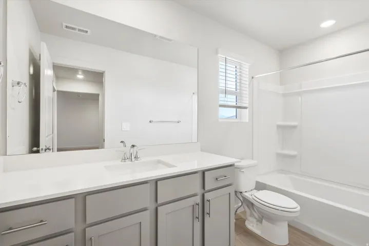 **DISCLAIMER** Interior package may vary. Bathroom featuring a wide vanity with light gray cabinetry, a white countertop, and a single undermount sink