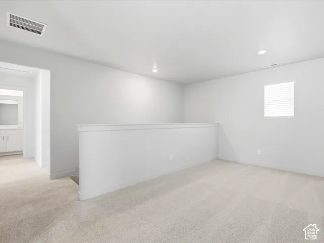 Neutral-toned wall-to-wall carpeting, crisp white wall finish, recessed ceiling lighting, and a window with horizontal blinds