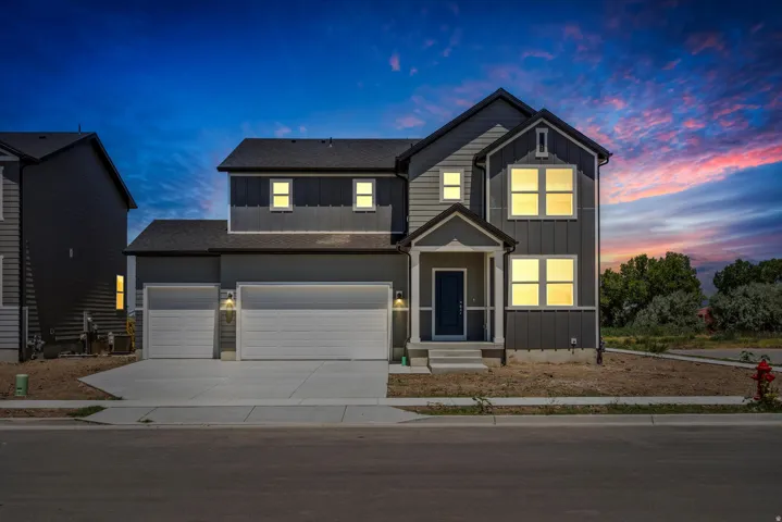 Two-story exterior featuring a covered front entry, a two-car garage, and an additional single-car garage