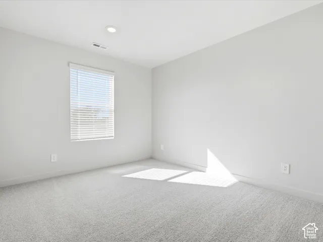Neutral interior featuring wall-to-wall carpeting, recessed ceiling lighting, and a horizontal blind window treatment