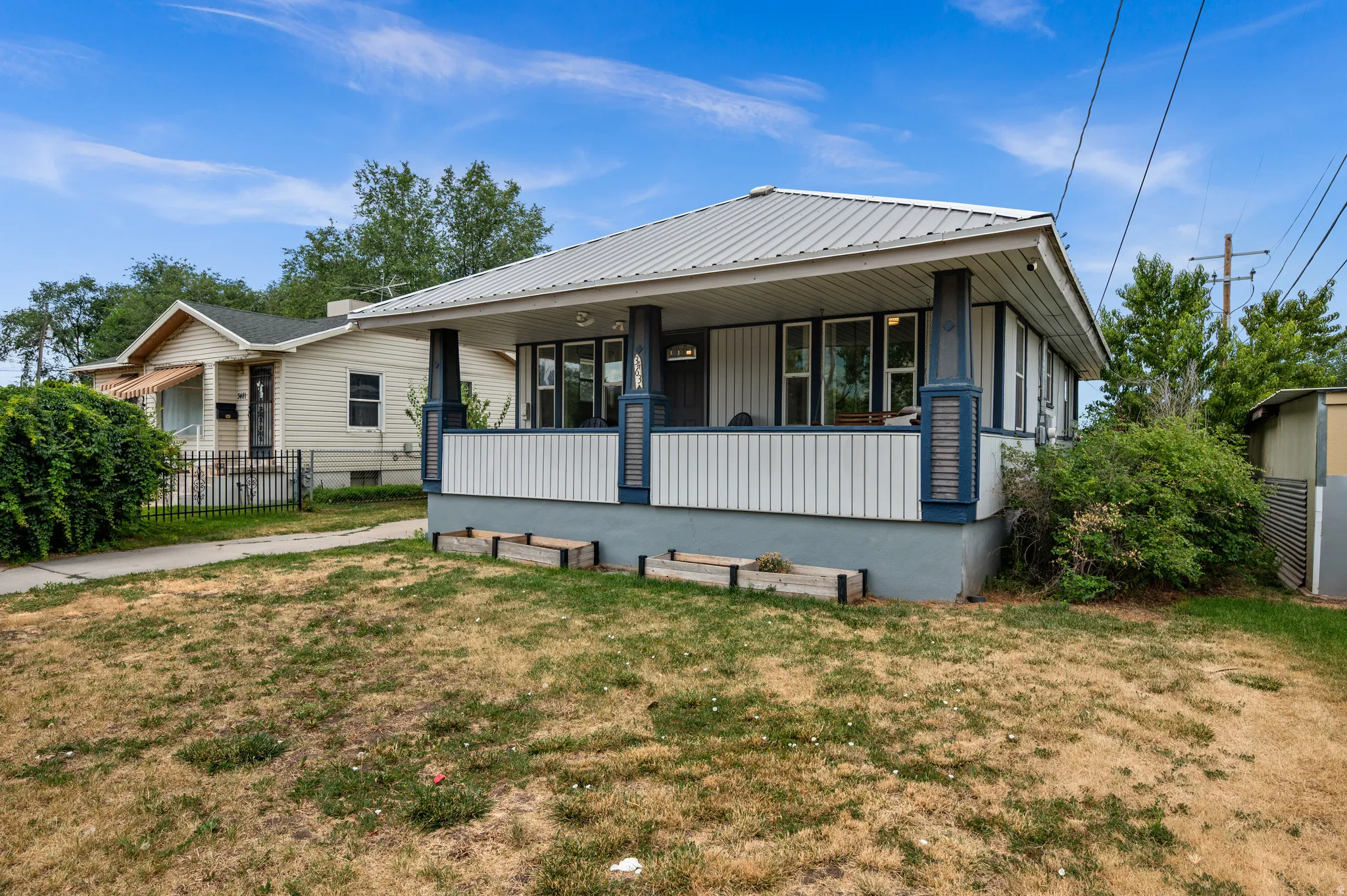 Front exterior featuring a covered porch with decorative columns, a metal roof, and horizontal siding