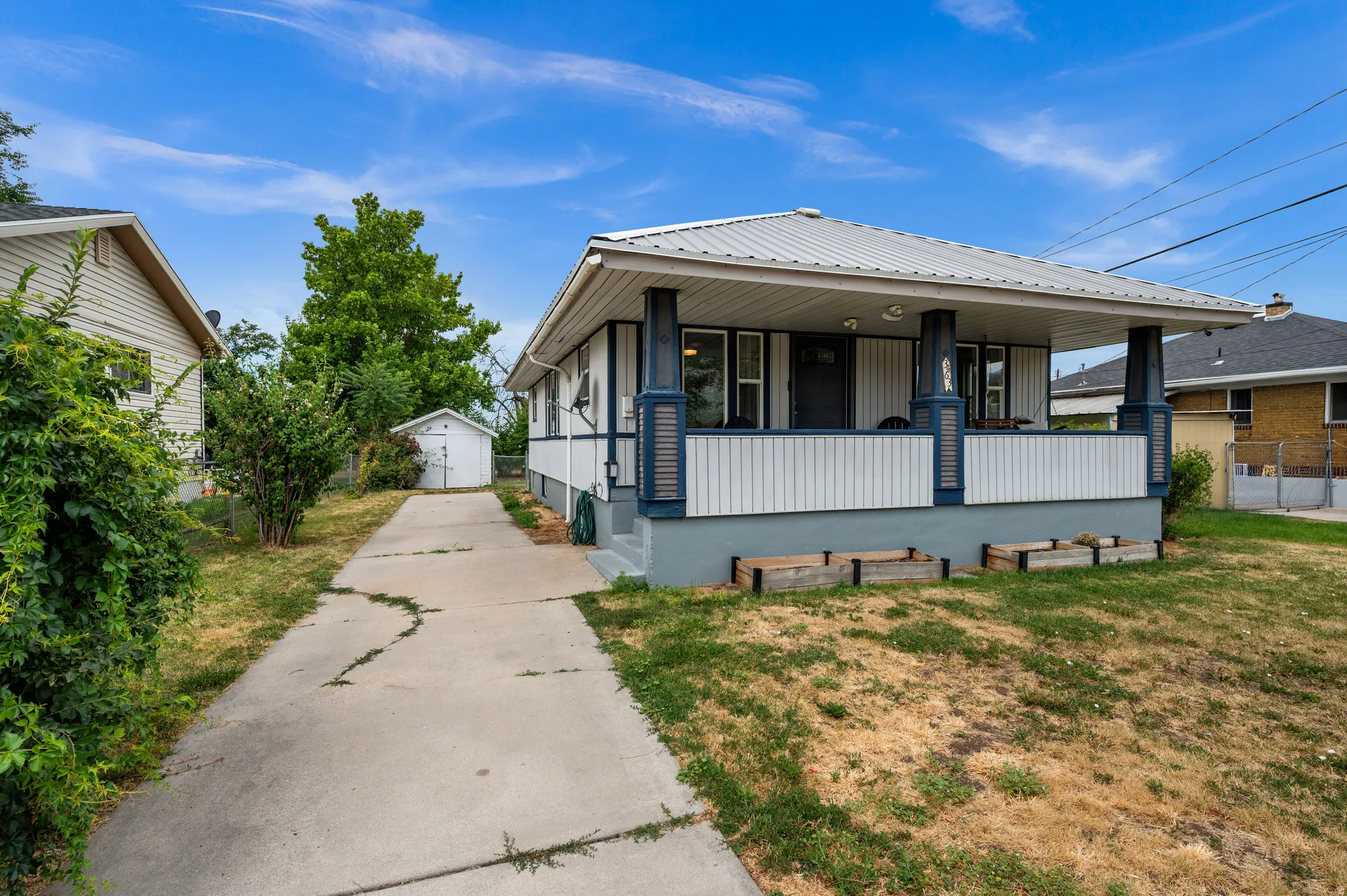 Front-facing property with a covered porch featuring white panel siding and contrasting trim