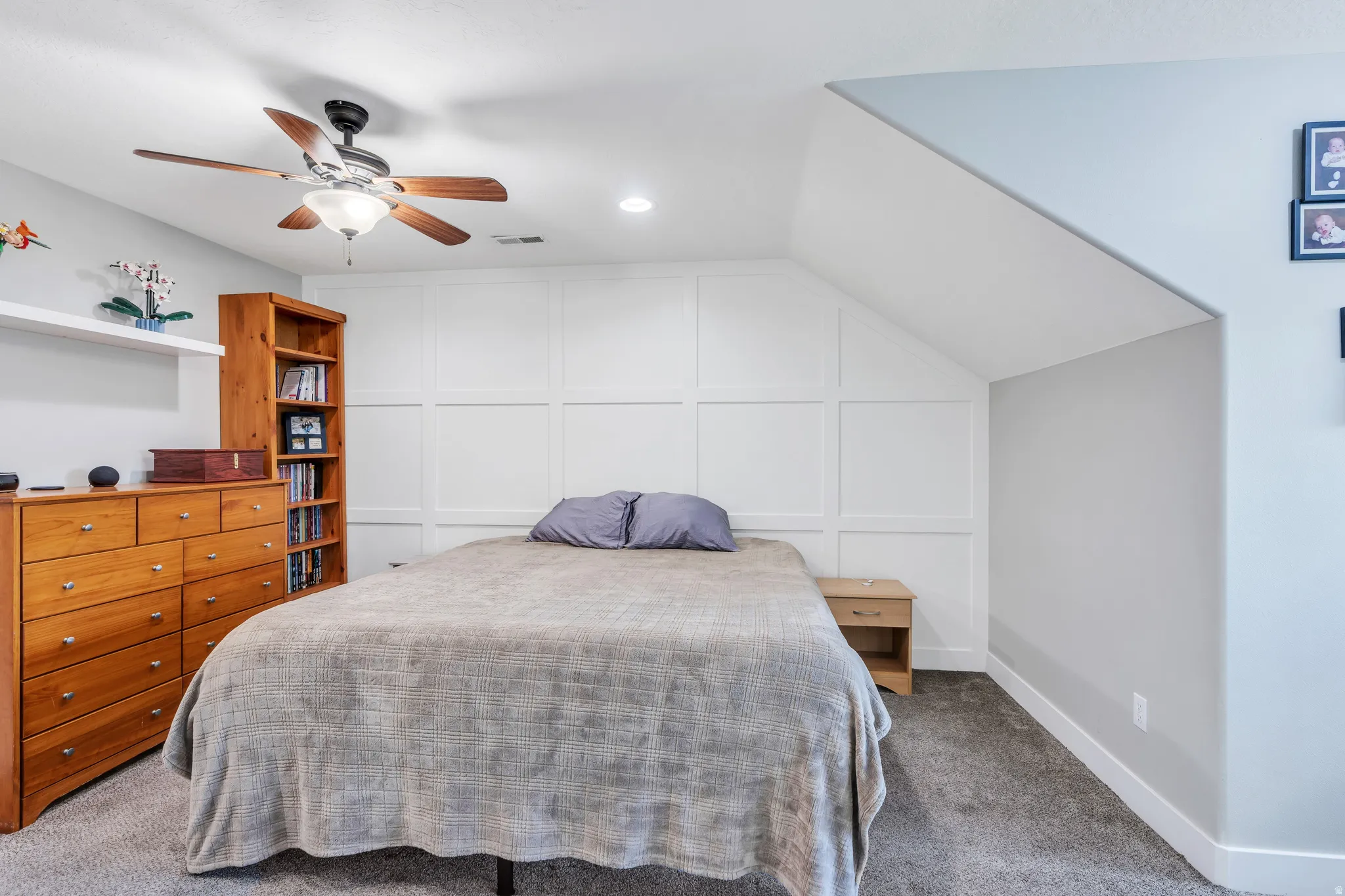Carpeted room featuring a ceiling fan with light fixture, recessed lighting, and a white accent wall with paneling