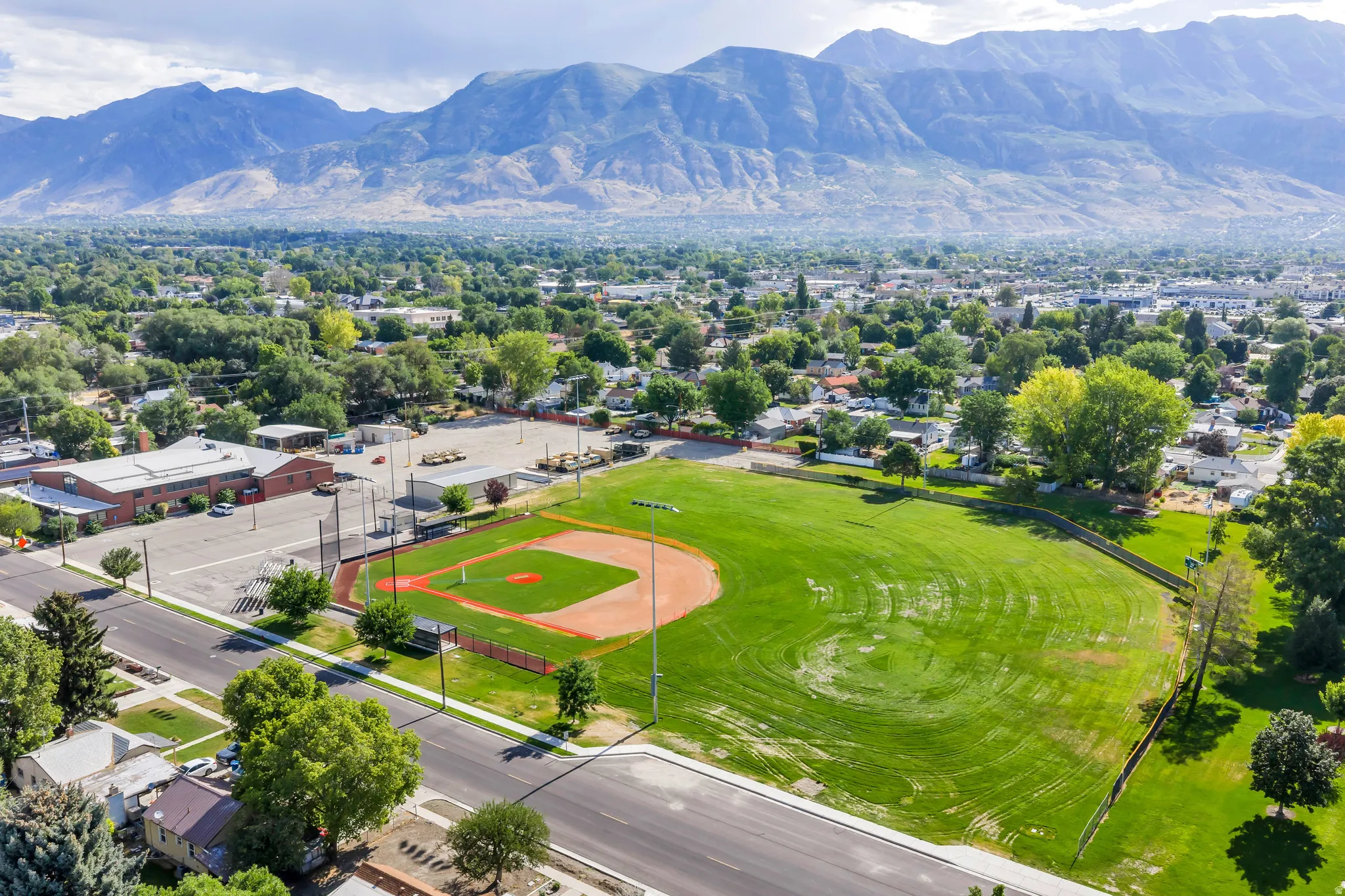 Expansive aerial perspective showcasing a neighborhood with mature trees and a prominent baseball field