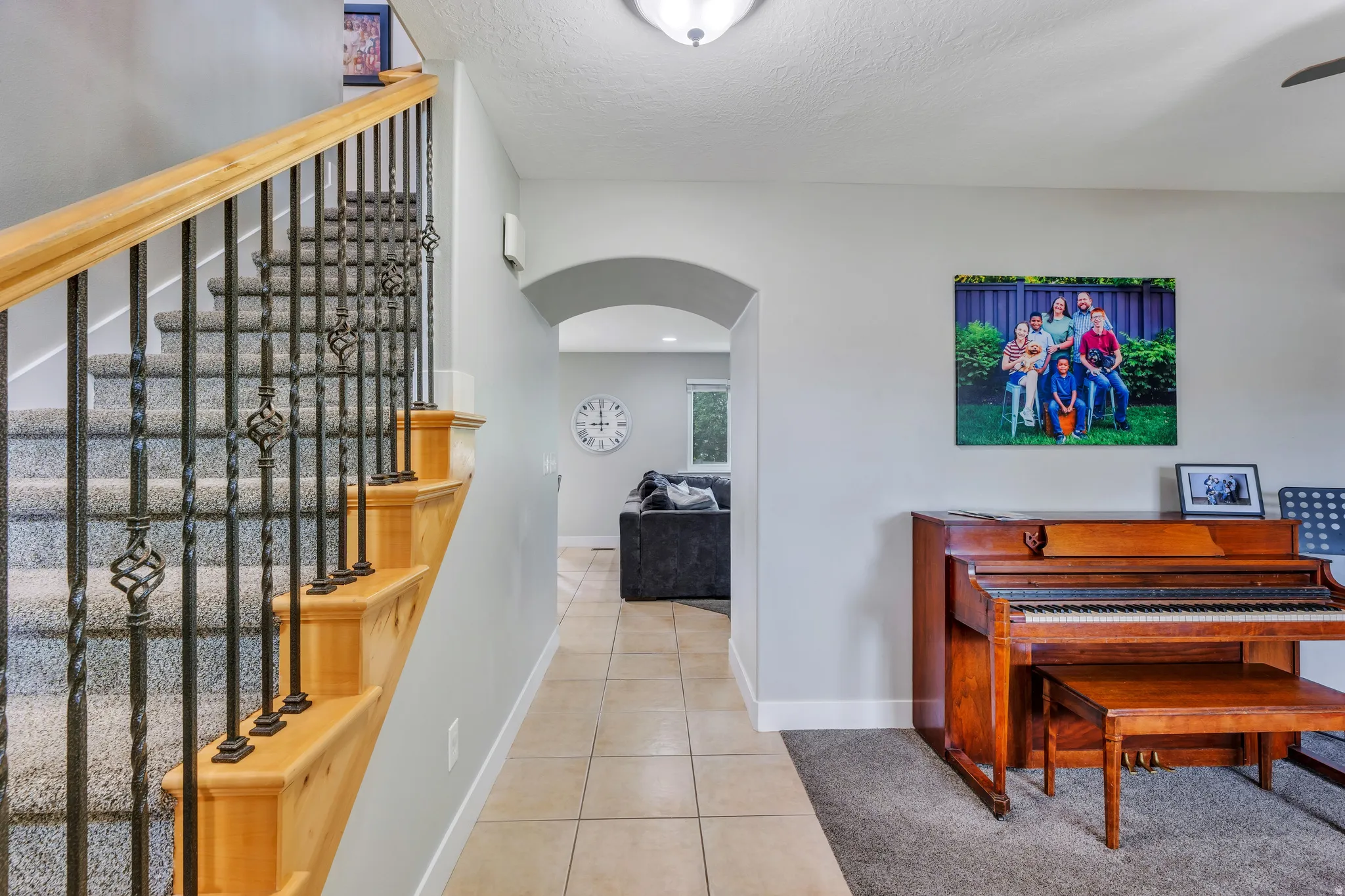 Staircase featuring wood handrails and wrought iron balusters with decorative elements, complemented by carpeted treads
