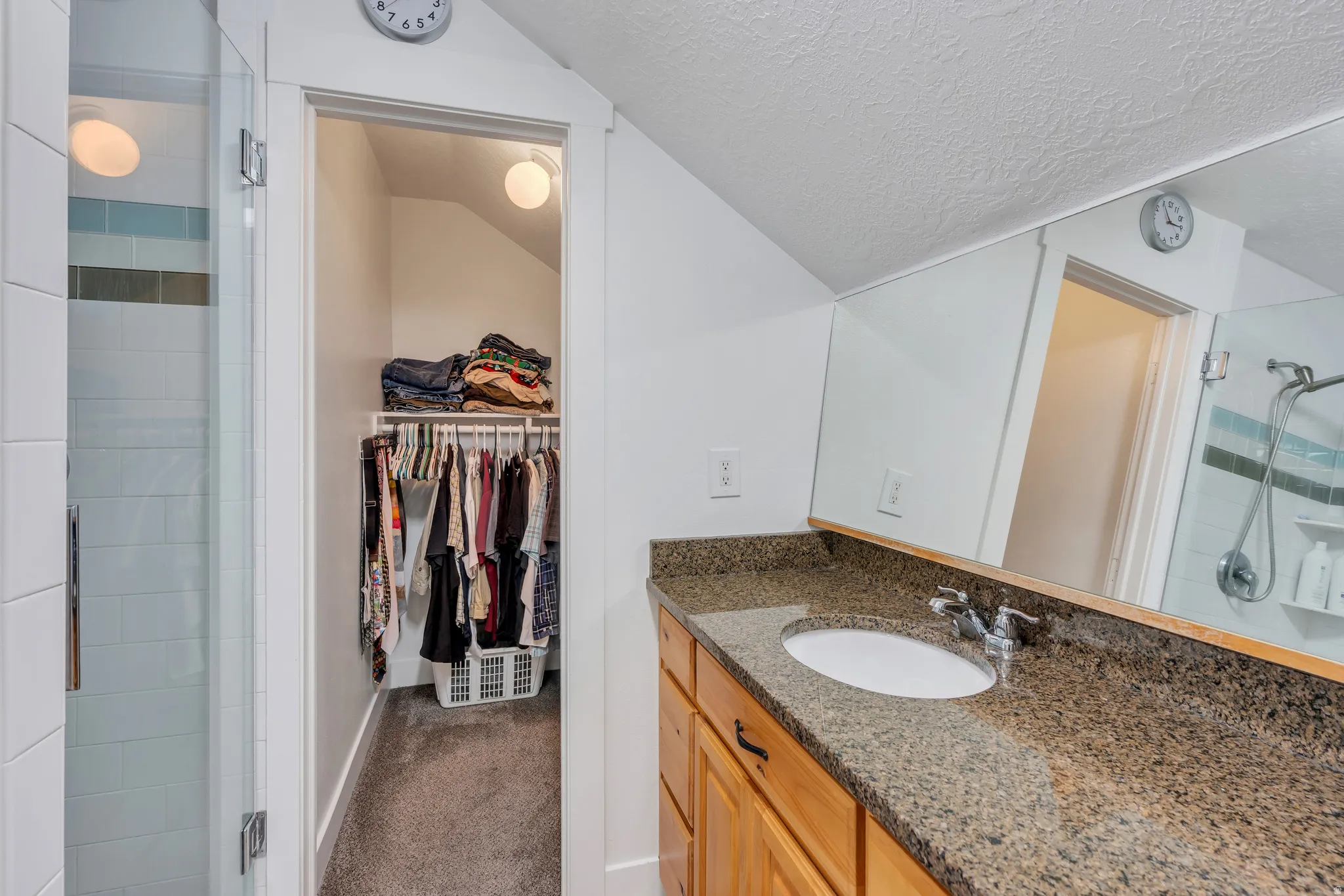 Bathroom featuring a granite-look countertop, wood-finish cabinetry, and a chrome faucet