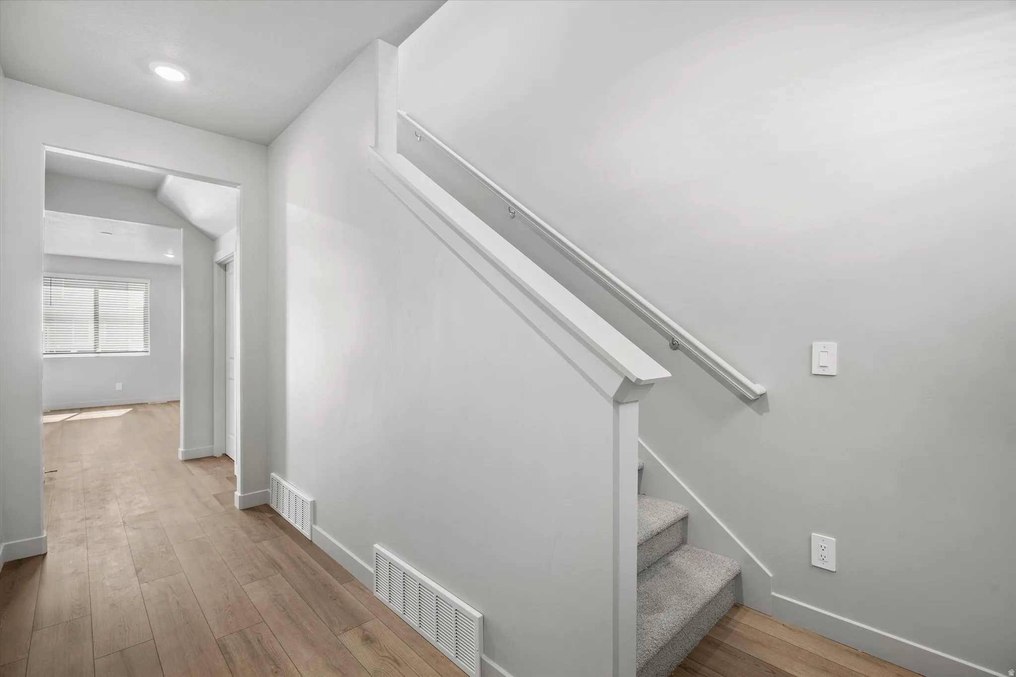 Entryway featuring wood-finish flooring extending into an open room