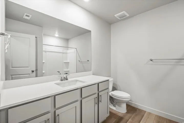Bathroom vanity with a rectangular undermount sink and a polished chrome faucet, set against a full-width mirror