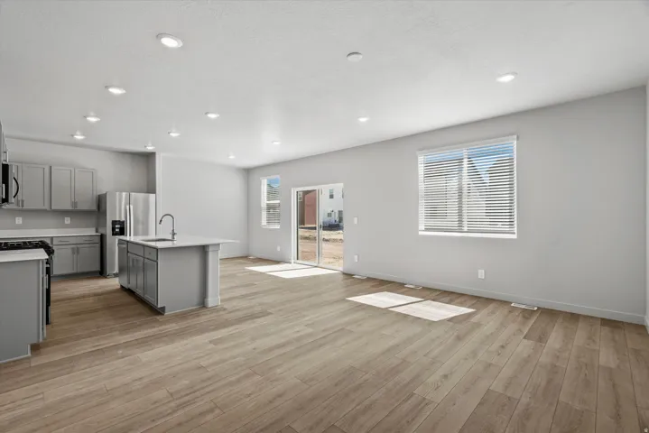 Open-concept living area featuring wood-finish flooring, recessed lighting, and light gray walls